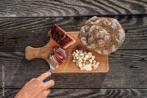 Snack with delicious South Tyrolean smoked bacon and cheese with flat bread lying on a rustic table photo