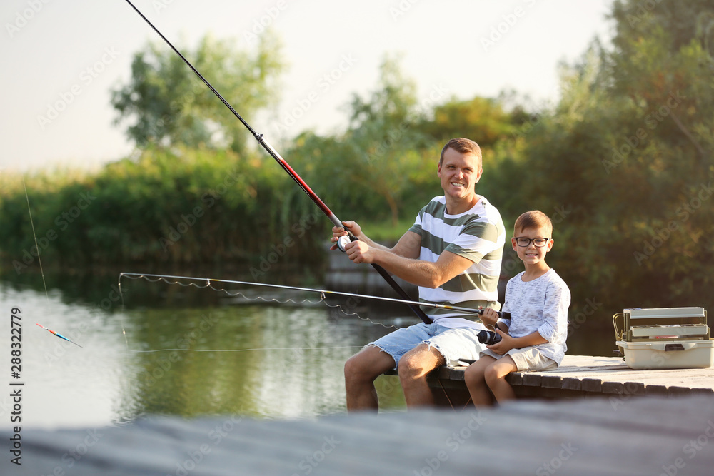Dad and son fishing together on sunny day Dad and son fishing together on sunny day