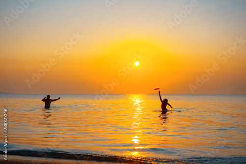 Two People in sea at sunset © Vladimir