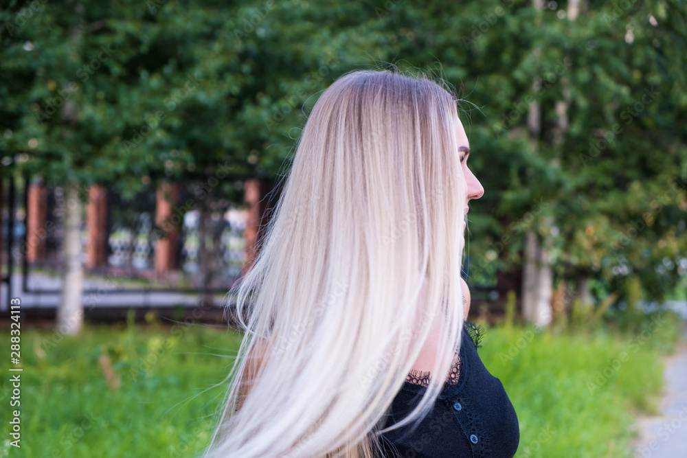 Portrait of a girl with long shiny blond hair. Back view. Hair care concept. Portrait of a girl with long shiny blond hair. Back view. Hair care concept.