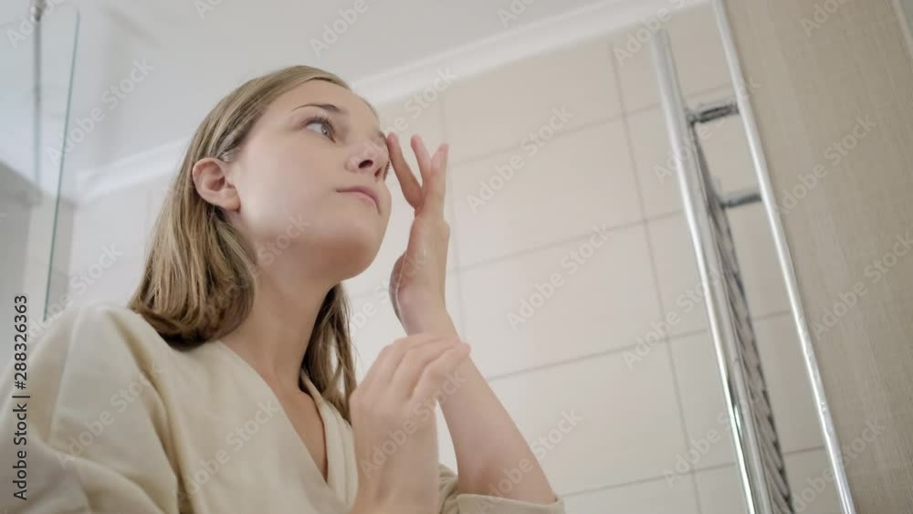 blond girl fixes hair behind ears and checks make-up blond girl fixes hair behind ears and checks make-up