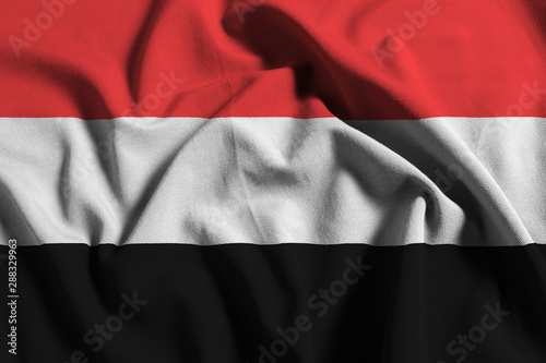 National flag of Yemen on a waving cotton texture background