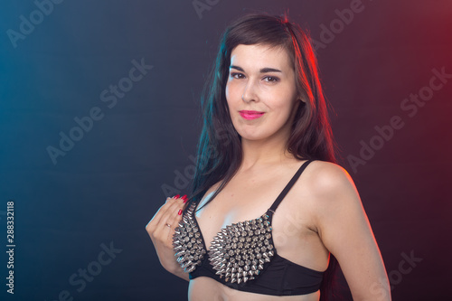 Alluring young beautiful brunette woman in a underwear posing on a dark background. Concept of seduction and sexual attractiveness