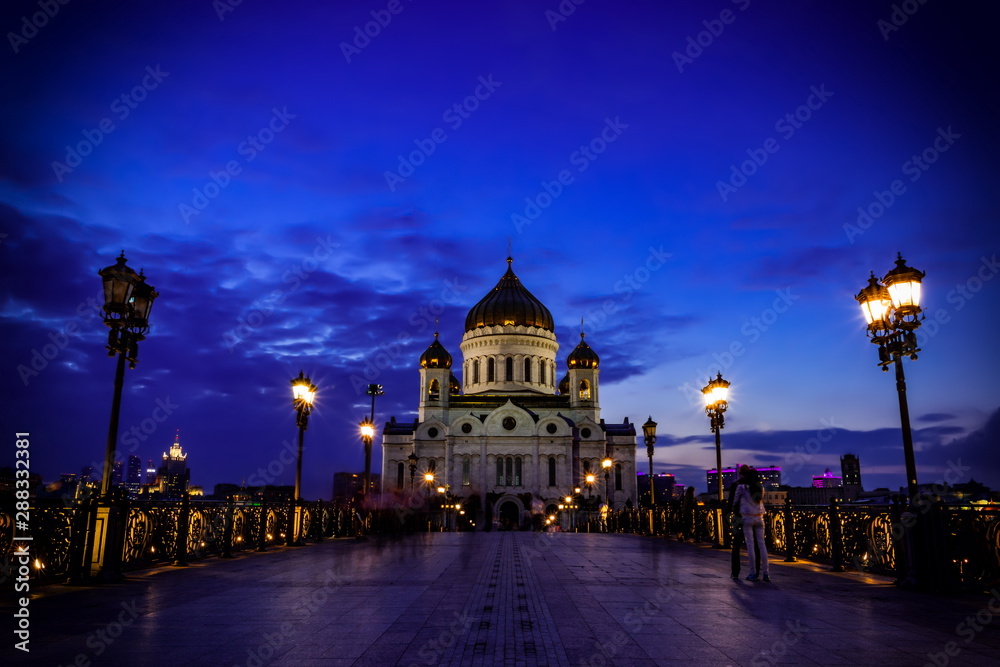 Obraz premium Illuminated Cathedral of Christ the Savior framed with old style street lights of Patriarchy Bridge at night.