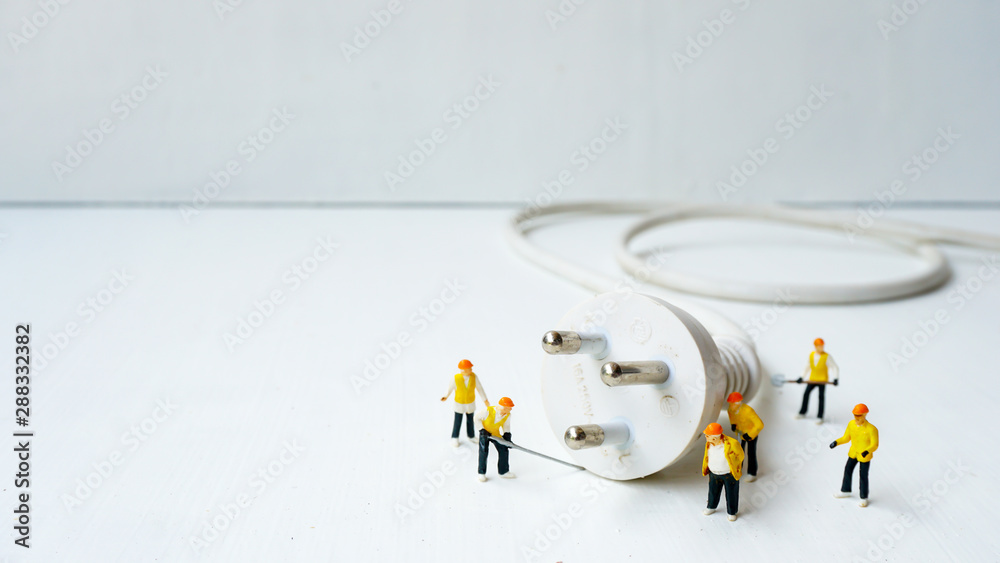 miniature electronic technician working to connect electricity