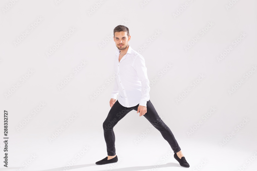 Handsome young man dancing on white background with copy space