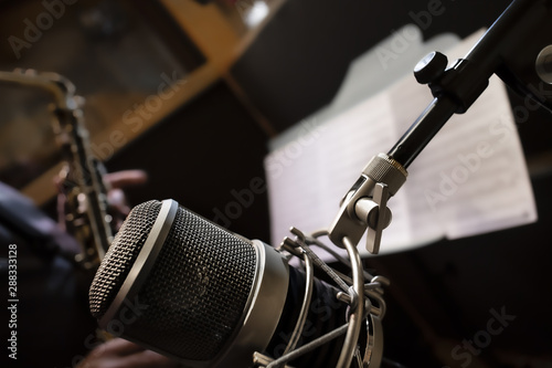 Microfono e musicista con sassofono e spartito in studio di registrazione photo
