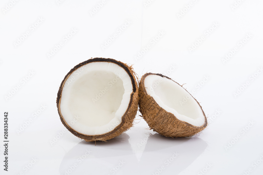 Coconut shell and grated coconut flakes on a brown wooden board isolated on white background. Coconut shell and grated coconut flakes on a brown wooden board isolated on white background.