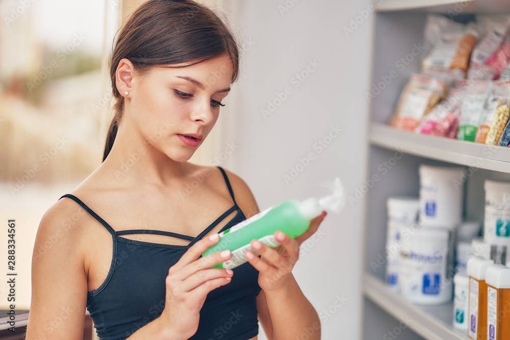 young girl chooses hot wax for hair removal at a showcase with samples young girl chooses hot wax for hair removal at a showcase with samples