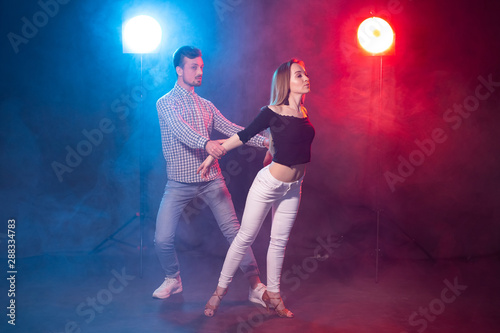 Social dance, kizomba, salsa and semba concept - young beautiful couple dancing bachata or salsa in the dark