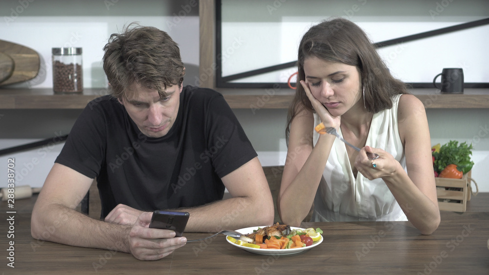Fighting Caucasian couple smart phone addict problem while eating dinner