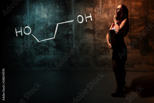 Sexy girl or secretary or female student presenting handdrawn chemical formula of propylene glycol -1,3 photo