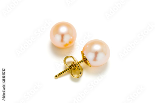 Pink cultured pearls on gold post make up these earring studs. Set on a white background.