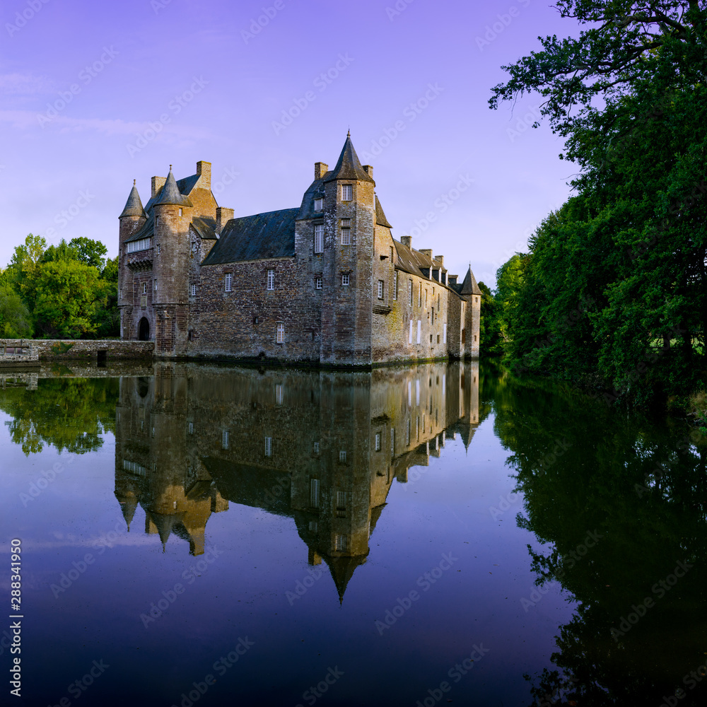 Campeneac, Brittany / France - 26 August 2019: Trecesson Castle reflected in the pond and surrounded by forest