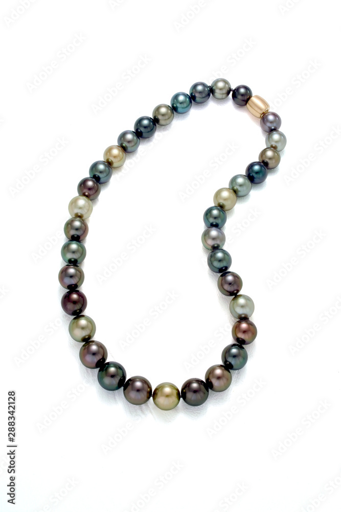 A necklace of a strand of multi colored tahition round pearls on a white background. A necklace of a strand of multi colored tahition round pearls on a white background.