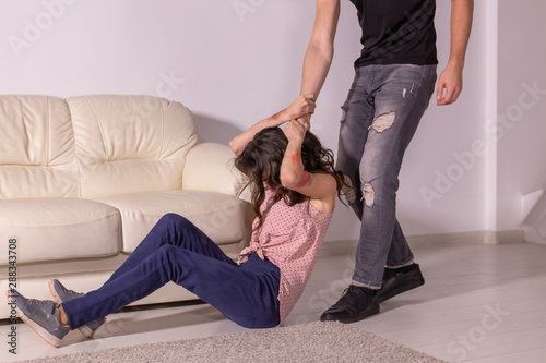 Domestic violence, abuse and victim concept - aggressive man dragging helpless woman by hair