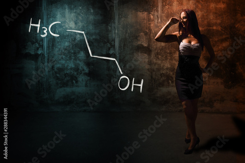 Sexy girl or secretary or female student presenting handdrawn chemical formula of n-butanol 1-butanol