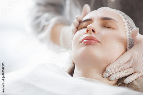 master making a cosmetic procedure for her client. skin care treatment. woman making a face care procedure.