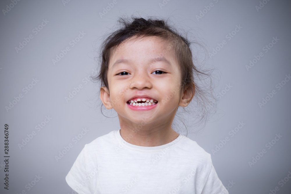 Portrait of a cute and adorable Asian young girl full of expression over grey background. Portrait of a cute and adorable Asian young girl full of expression over grey background.