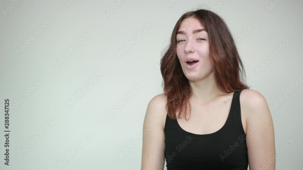 beautiful girl in black tank top over isolated white background shows emotions beautiful girl in black tank top over isolated white background shows emotions