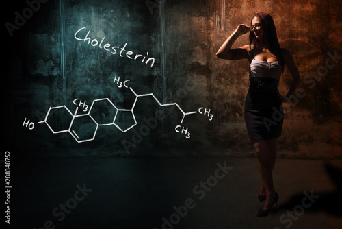 Sexy girl or secretary or female student presenting handdrawn chemical formula of Cholesterol photo