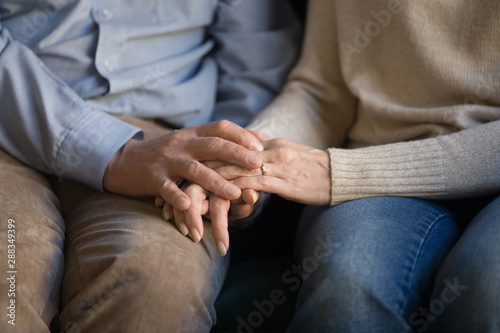 Close up middle aged family couple holding hands, supporting.