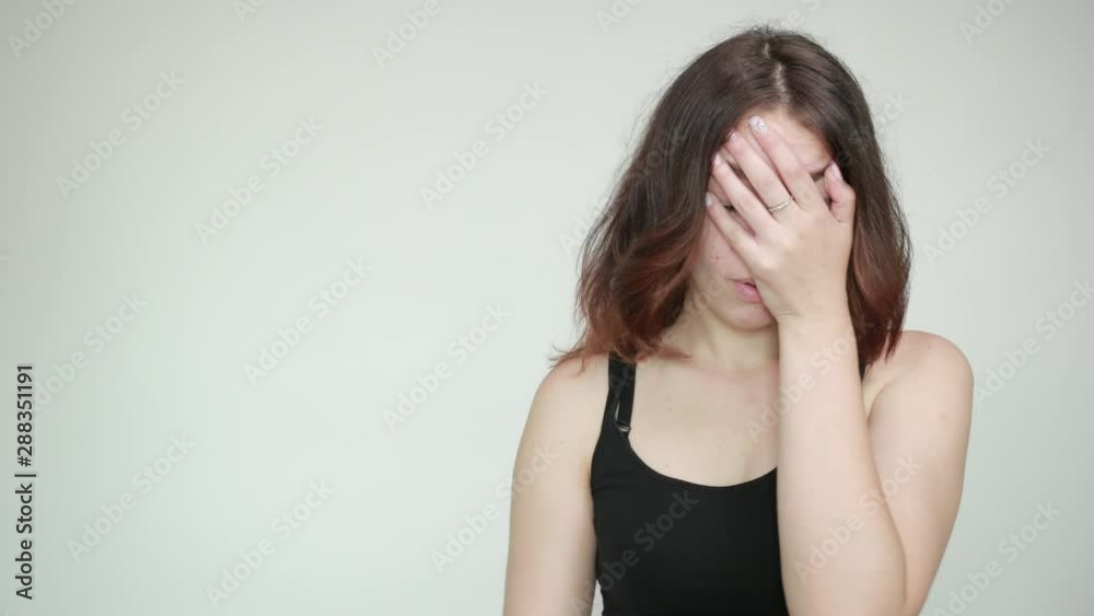 beautiful girl in black tank top over isolated white background shows emotions beautiful girl in black tank top over isolated white background shows emotions