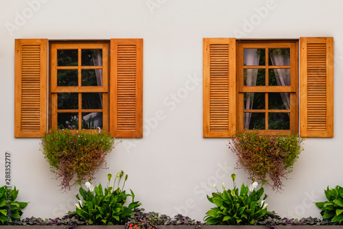 Vintage windows with open wooden shutters and fresh flowers photo