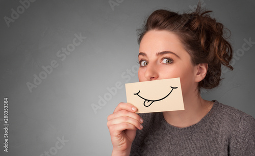 Person with smile card in front of his mouth