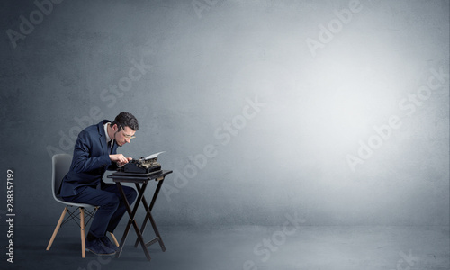 Man working hard on a typewriter in an empty space © ra2 studio