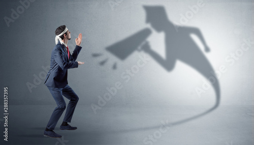 Businessman fighting with his bossy yelling shadow