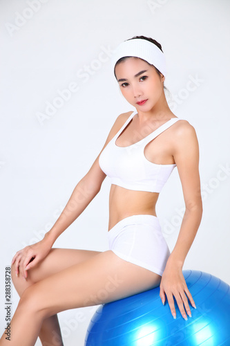 Young pretty woman with gym ball on white background
