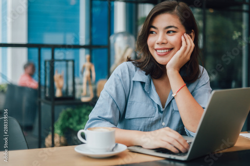 Canvas Print Asian woman in blue shirt  in cafe drinking coffee and talking with boy friend s
