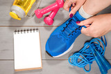 Gym exercise list mockup, dumbbells and a skipping rope on blue background.