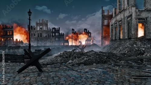 Photography Ruined after the bombing of the World War 2 european city with burning building ruins and street barricade on foreground at night