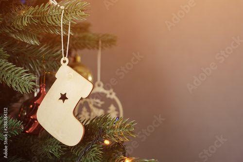 christmas boot wooden decoration on artificial new year tree, copyspace
