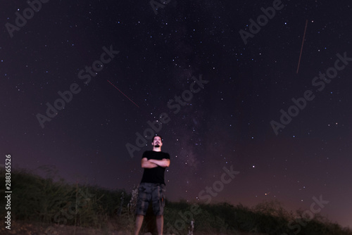 posing man in night portrait with milky way in background