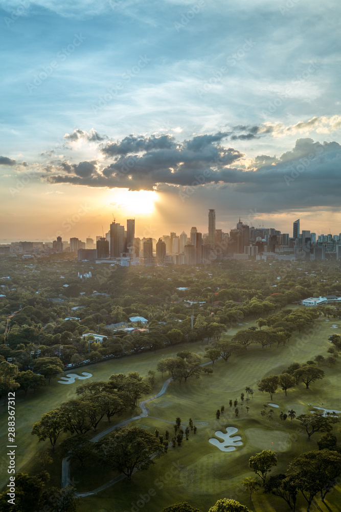 Golf course and Skyline of Manila, Philippines, in a beautiful sunset.