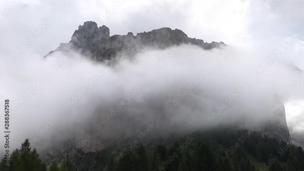 Time-lapse of clouds rolling over fir trees against mountains, the Dolomites, Italy. Time-lapse of clouds rolling over fir trees against mountains, the Dolomites, Italy.