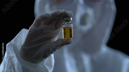 Researcher showing bottle with vaccine to camera, poison antidote development