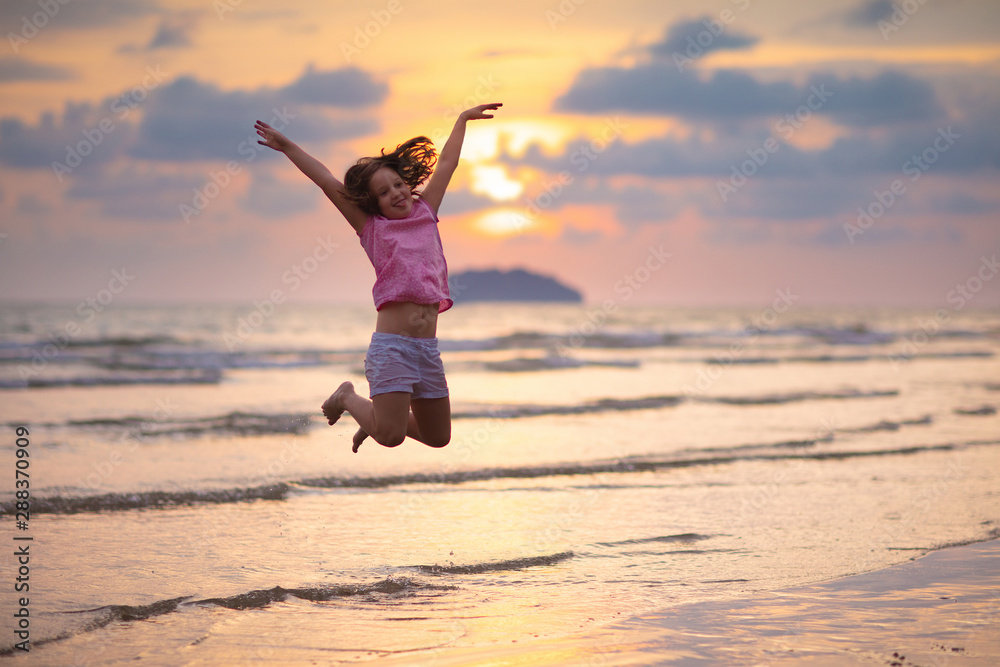 Child playing on ocean beach. Kid at sunset sea. Child playing on ocean beach. Kid at sunset sea.