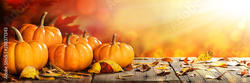 Banner Of Thanksgiving Pumpkins And Leaves On Rustic Wooden Table With Sunlight And Bokeh On Orange Background - Thanksgiving / Harvest Concept