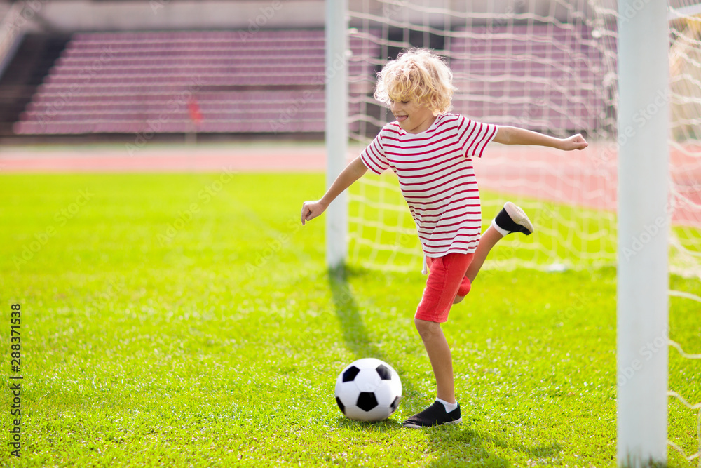 Obraz premium Kids play football. Child at soccer field.