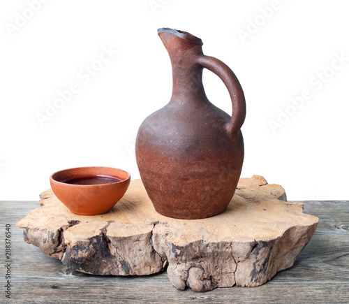 Wine jug and clay cups on the wooden table photo