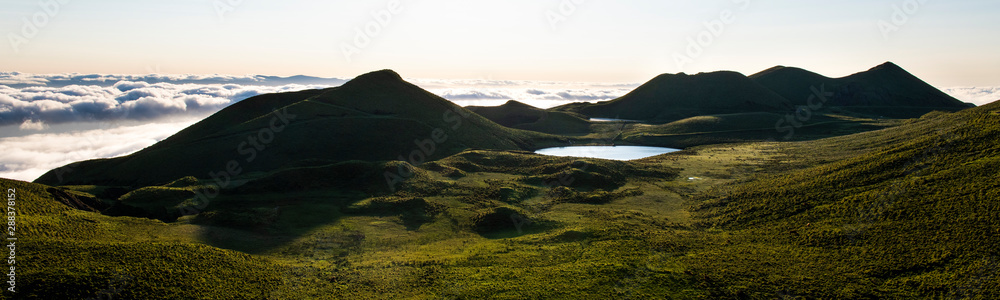 Amazing panorama landscape above the cloudline at Pico Island showing Lago de Peixinho (Lagoa do Peixinho), green meadows and clouds above the Ocean.