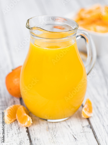 Homemade Tangerine Juice on a wooden table (selective focus)