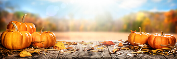 Thanksgiving Pumpkins And Leaves On Rustic Wooden Table With Sunlight And Bokeh On Autumn Background - Thanksgiving / Harvest Concept