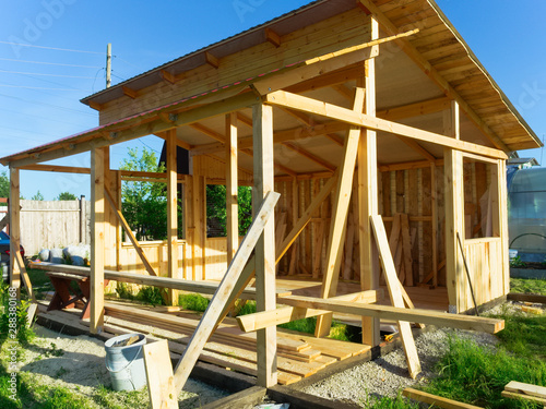 Unfinished building, summer house made of eco materials. Assembly of a wooden house