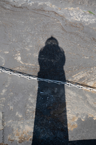 Shadow of the Lighthouse of Ponta dos Capelinhos on the volcanic lavacoast from 1957-58 eruption photo