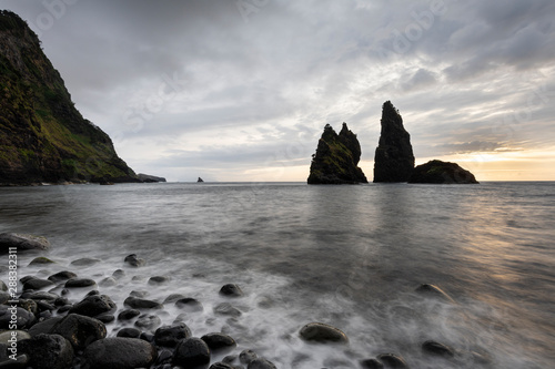 Sunrise landscape at rock structures in the sea at Baía de Alagoa on the fairy tale island of Ilha das Flores, Azores photo